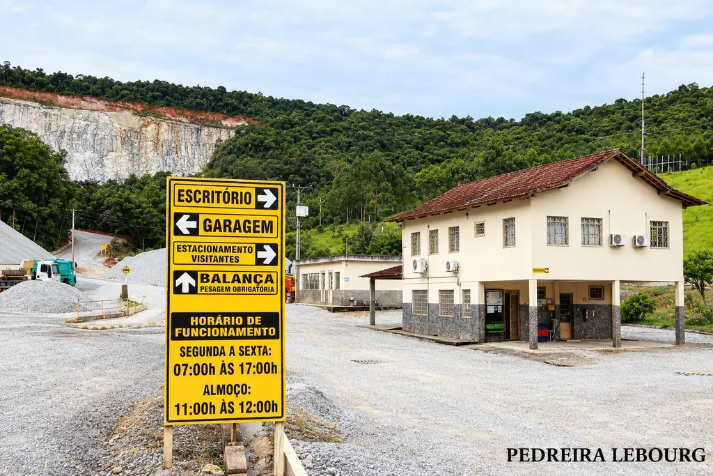 Escritório da Pedreira Lebourg, com a placa de horário de funcionamento e a frente de lavra de granito ao fundo